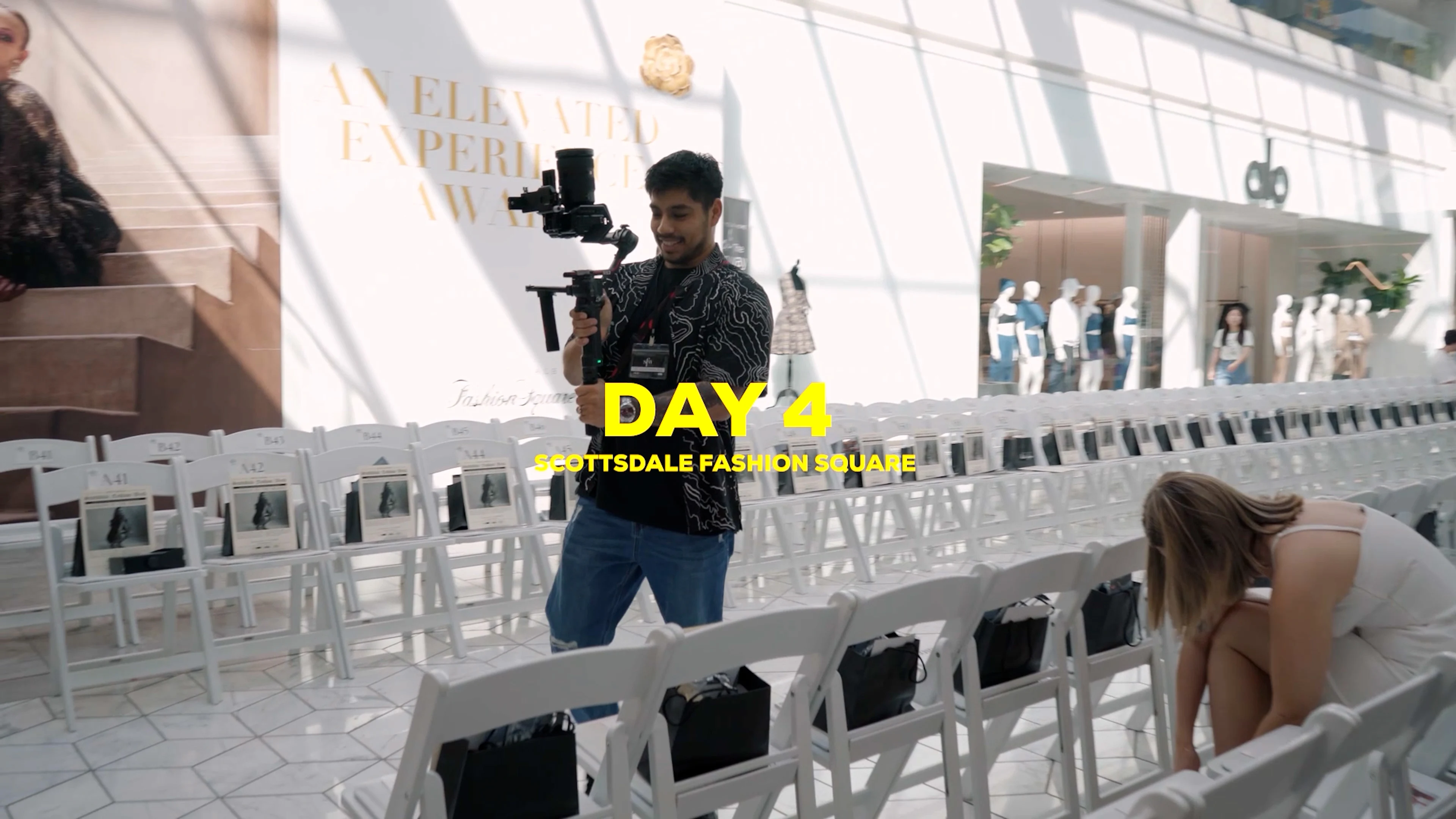 Haute Shots camera operator with a gimbal rig walking the empty runway seating setup before the Scottsdale Fashion Week show.
